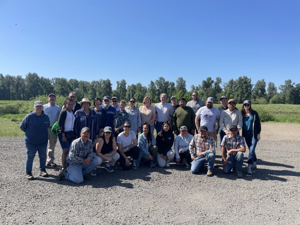 Large group of food supply and distribution industry professionals posing together during an agricultural field visit, showcasing B2B food sector collaboration and farm-to-table partnerships.