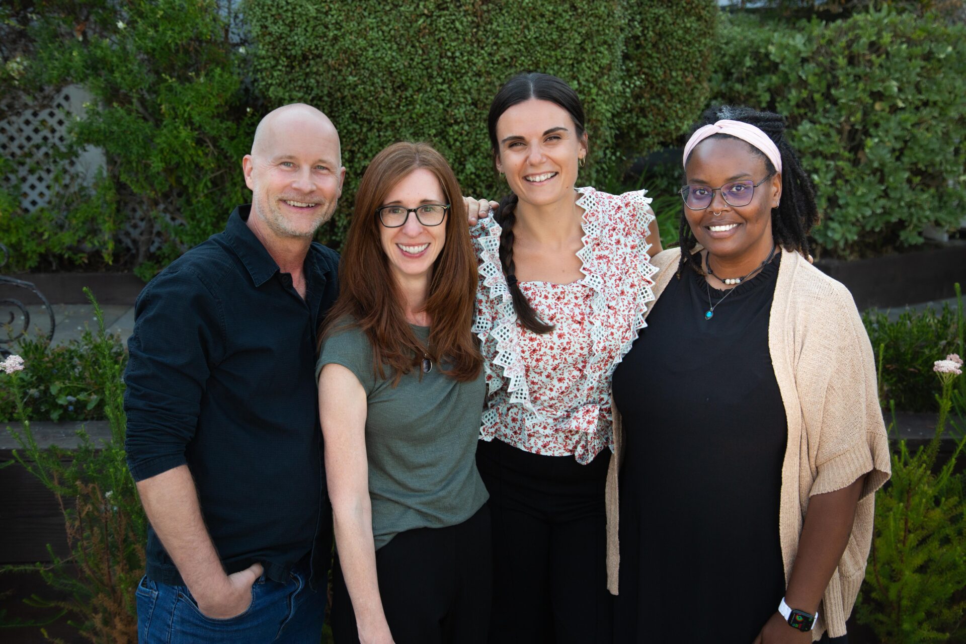 Four smiling food service industry professionals posing together at an outdoor corporate event, representing food suppliers and distributors.