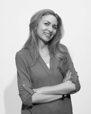 Professional woman in business blazer posing with arms crossed, ideal for food industry B2B and wholesale company profiles.